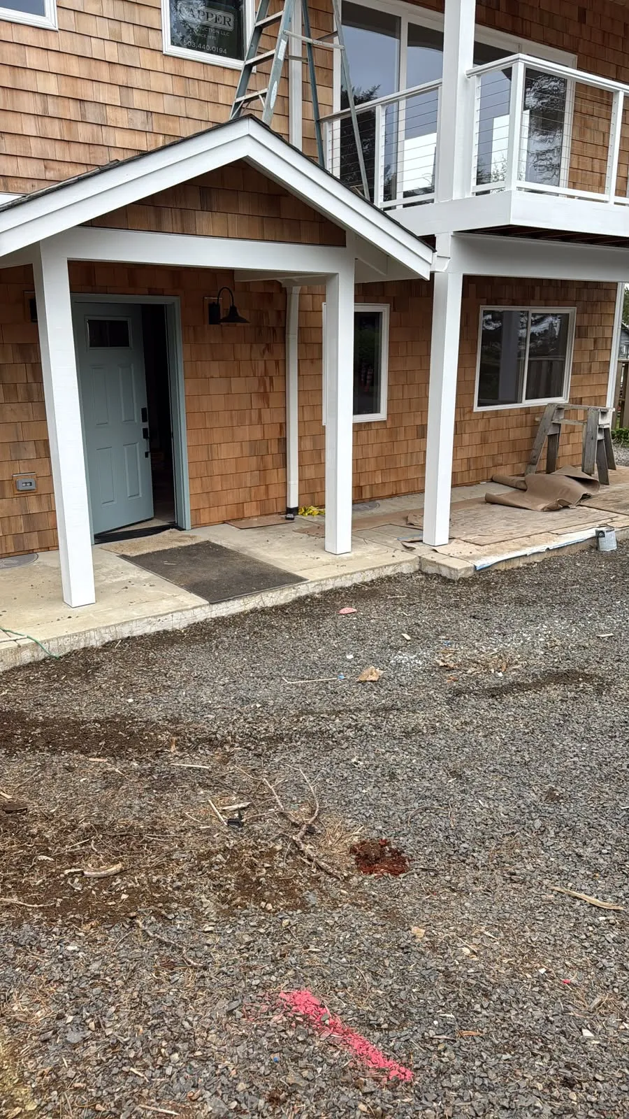 Covered front porch with white posts and trim on a cedar shake house