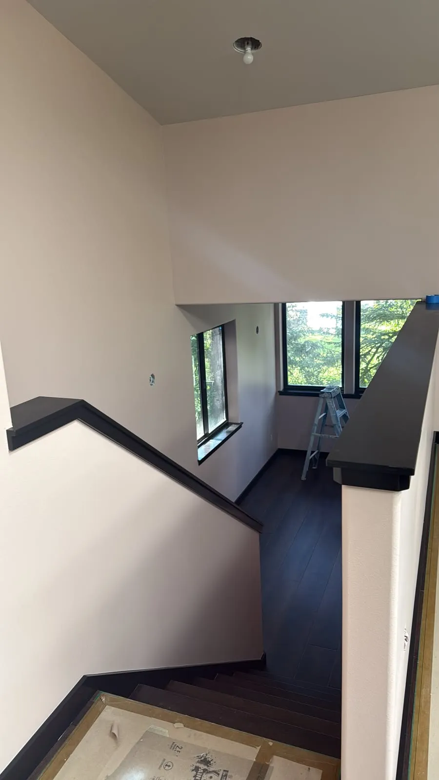 Stairwell with light walls and a dark handrail cap