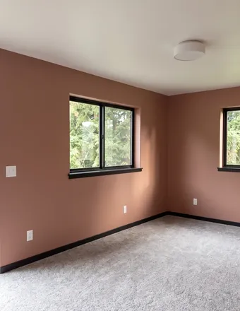Bedroom with clay-colored terracotta walls and black-painted trim